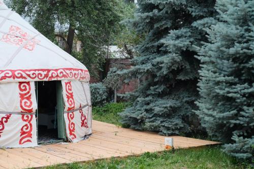 una tenda rossa e bianca appoggiata su un ponte di legno di 70 Years Old Yurt Experience Almaty a Almaty