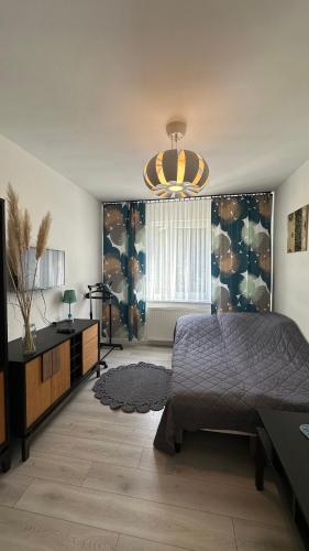 a bedroom with a bed and a chandelier at Dom wakacyjny z basenem i sauną GWIZD Ustronie Morskie in Grąbnica