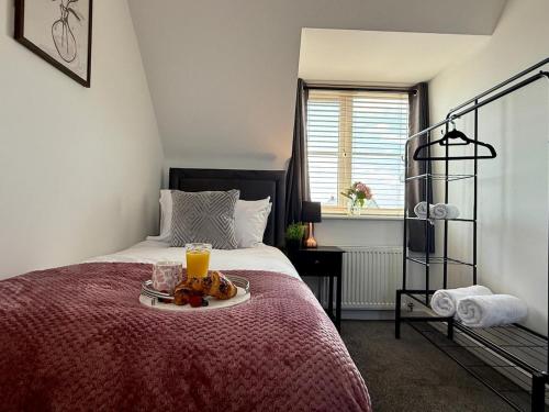a bedroom with a bed with a plate of food on it at Spacious 5-Bed Home in Birstall - Sleeps 13 - Free Parking- WiFi - Patio - Garden - Meadow Views in Thurcaston