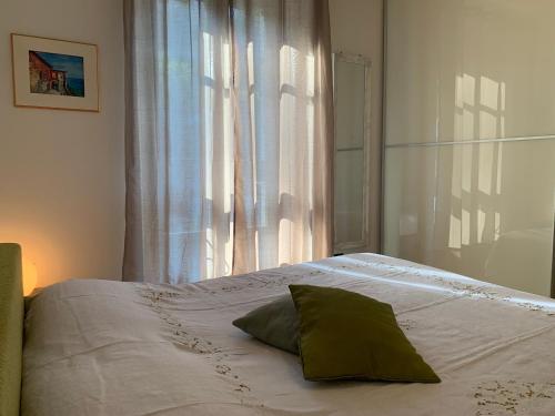 a bed with a pillow on it in front of a window at VECCHIA STAZIONE - by Satisfactual Property in Menaggio
