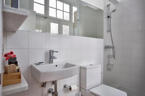 a white bathroom with a sink and a toilet at Apartamento en casco antiguo - Cerca de la playa in Marbella