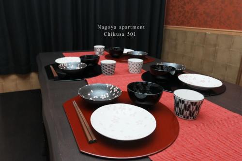 a table with black and white plates and utensils at Prosper 5th bldg 501 in Nagoya