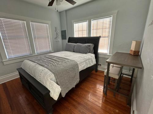 a bedroom with a bed and a table and windows at Deland Serenity Place #2 in DeLand