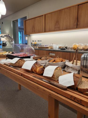 a table with a bunch of different types of bread at Hotel Alpenruhe - Vintage Design Hotel in Wengen