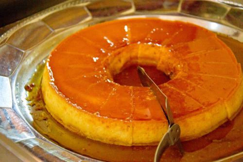 a cake sitting on top of a plate with a knife at Hotel 2 Irmãos in Campo Grande