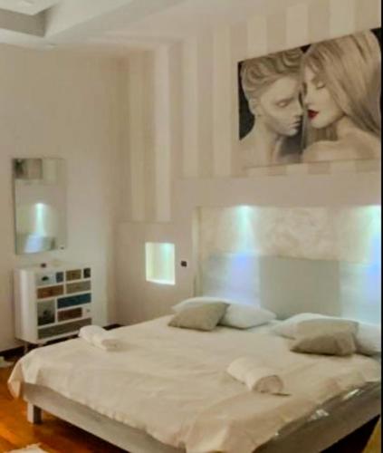 a bedroom with a bed with a painting on the wall at B&B by Family L&G in Vibo Valentia Marina