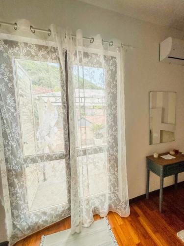 a room with a window with curtains and a table at B&B by Family L&G in Vibo Valentia Marina