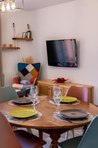 ein Holztisch mit Tellern und Weingläsern darauf in der Unterkunft T2 cosy avec terrasse - proche plage & Sanary in Six-Fours-les-Plages