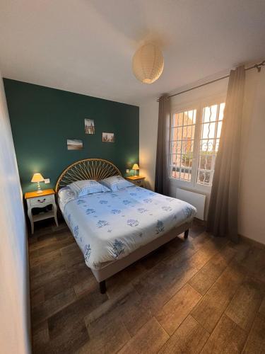 ein Schlafzimmer mit einem Bett und einer grünen Wand in der Unterkunft T2 cosy avec terrasse - proche plage & Sanary in Six-Fours-les-Plages