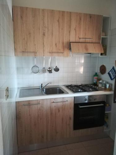 a kitchen with wooden cabinets and a sink and a stove at Villetta sul Mare in Stintino