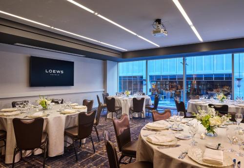 a banquet room with tables and chairs and a projection screen at Loews Chicago Hotel in Chicago