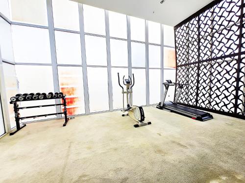 a room with a gym with a treadmill and a bench at Apt Oasis 1BR Cikarang japanese in Jatirarangan