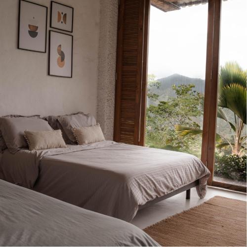 a bedroom with two beds and a large window at Kasaurora in Tobia