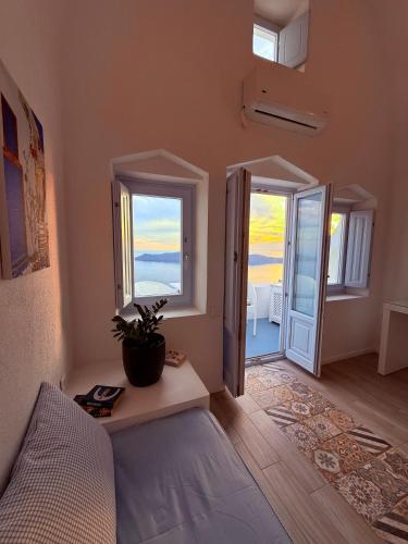 a bedroom with a bed and a door with a window at Sunset Caldera Seaview Houses in Imerovigli
