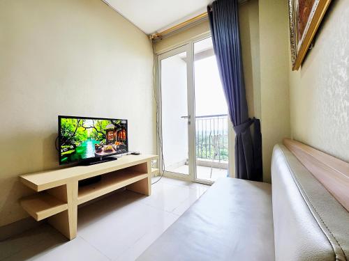 a living room with a tv and a large window at Apt Oasis 1BR Cikarang japanese in Jatirarangan