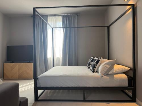 a bedroom with a canopy bed with a window at JR HOME Apuania in Massa