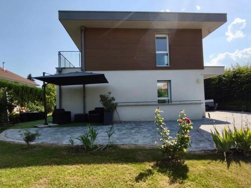 a house with an umbrella in front of it at Elegant House near Château de Voltaire in Prévessin