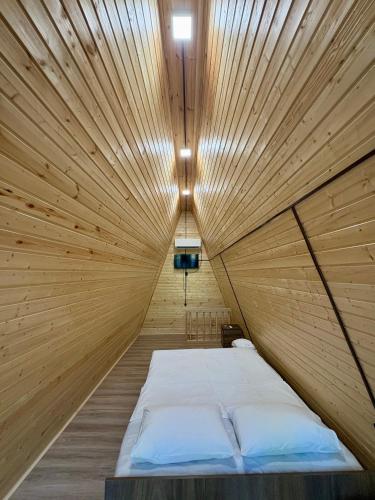 a bed in a wooden room with a ceiling at Wooden House Martvili in Martvili