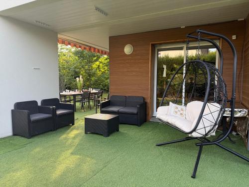 a living room with a swing and a patio at Elegant House near Château de Voltaire in Prévessin