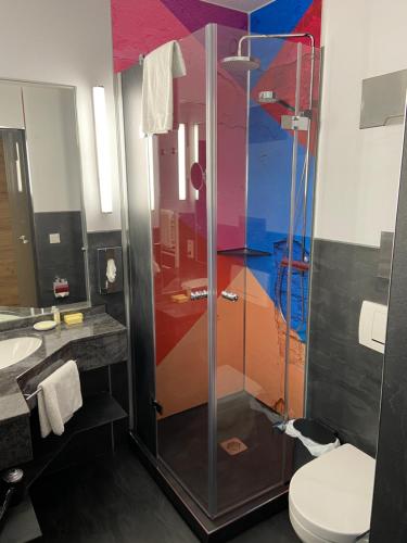 a bathroom with a shower and a toilet at Hotel Touric in Korbach