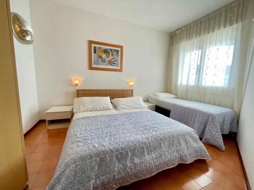 a bedroom with two beds and a window at Apartment in Porto Santa Margherita 43488 in Porto Santa Margherita di Caorle