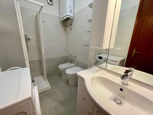 a white bathroom with a sink and a toilet at Apartment in Porto Santa Margherita 43488 in Porto Santa Margherita di Caorle