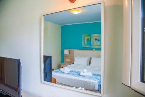 a mirror reflection of a bed in a room at Princess Hotel in Lassi