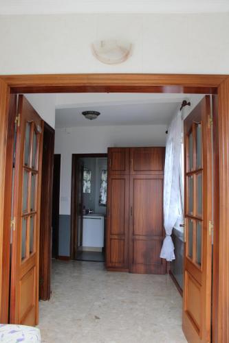 otwarty korytarz z drewnianymi drzwiami i kuchnią w obiekcie Casa Amadora w mieście Carnota