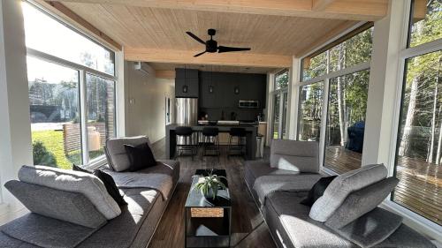 a living room with two couches and a table at Scenic Bright - Sauna - Fire - 20 min Tremblant in La Conception