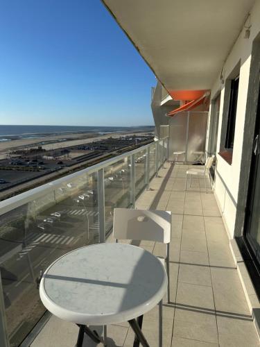 une table et des chaises sur le balcon d'un bâtiment dans l'établissement LTPP T2 face mer, à Le Touquet-Paris-Plage