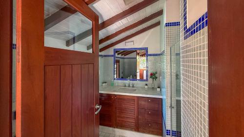 Un baño con lavabo y puerta de madera. en Villa Giulia Morro, en Morro de São Paulo