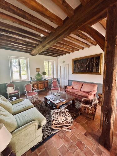 a living room with two couches and a table at Manoir de Daubeuf in Daubeuf-Serville