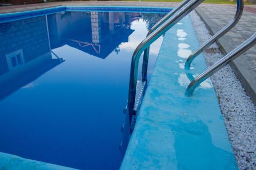 Usa RiverにあるKilimanjaro Eco Lodgeの青い水と金属製のレール付きのスイミングプール