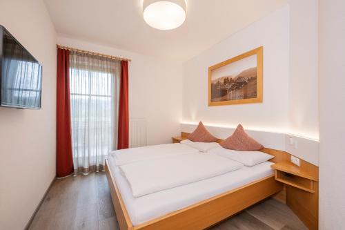 a bedroom with a large bed with white sheets at Anewandterhof in Brunico