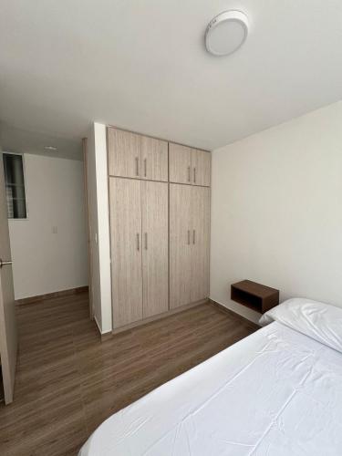 a bedroom with a large white bed and a closet at alojamiento en apartamento moderno in Manizales