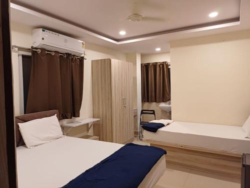 a hotel room with two beds and a room with at Sahasra Sree Suites Inn in Hyderabad