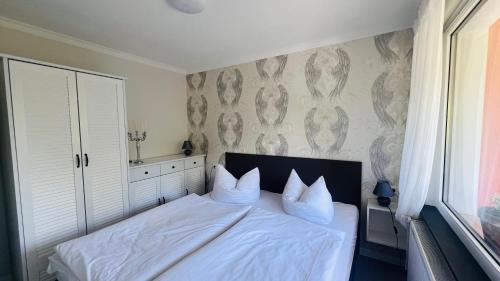a bed with white sheets and pillows in a bedroom at Maison Lily Apartment 5 in Bad Lauterberg