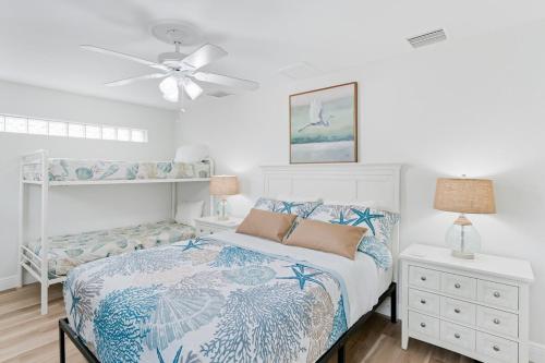 a white bedroom with a bed and a ceiling fan at Modern Coastal Home in Clearwater Beach