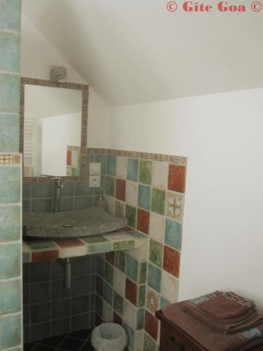 a bathroom with a sink and a mirror at Gîte Bülbül in Gouézec