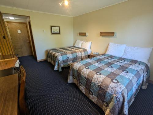 a hotel room with two beds and a television at Mariner motor hotel in Collingwood