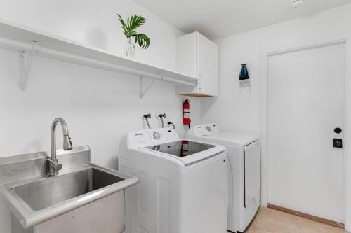 a white kitchen with a sink and a washing machine at Modern Coastal Home in Clearwater Beach