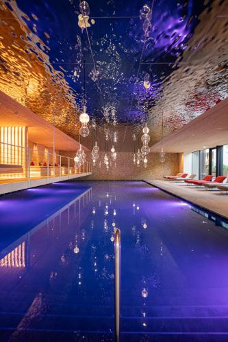 a swimming pool in a building with a ceiling with lights at Anewandterhof in Brunico
