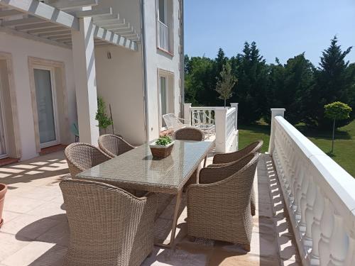 a patio with a table and chairs on a balcony at Le Charme des Bastides in Castelnau-de-Montmiral