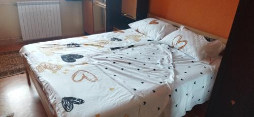 Una cama con un edredón blanco con mariposas. en Таra 2, en Bitola