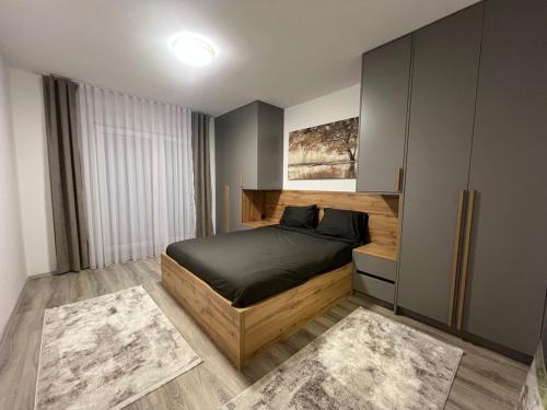 a bedroom with a large bed and a cabinet at Art superior apartment in Kosovo Polje