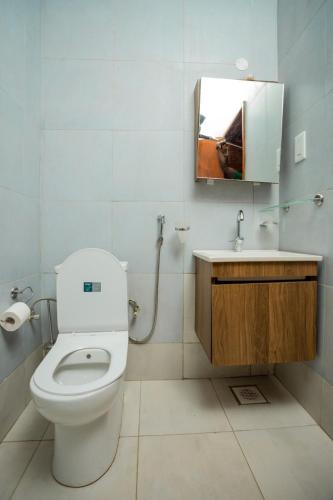 a bathroom with a toilet and a sink and a mirror at Edrin Apartments in Kampala
