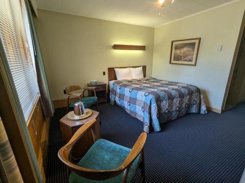 a hotel room with a bed and a table and chairs at Mariner motor hotel in Collingwood