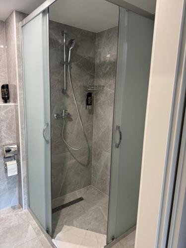 a shower with a glass door in a bathroom at Hotel Pension Schwansee in Schwangau