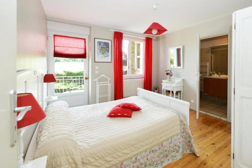 - une chambre avec un lit doté d'oreillers rouges dans l'établissement Lou Caussinhol 3 épis, à Montbazens