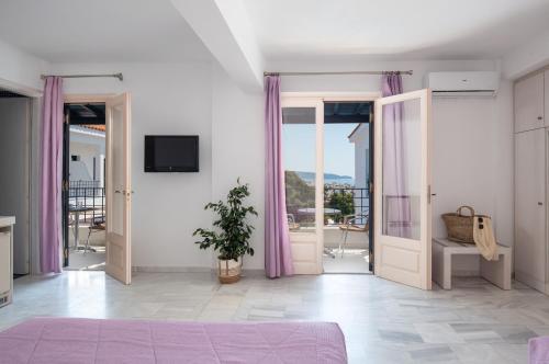 a bedroom with doors open to a balcony at Atrium of Alonissos in Patitiri